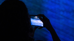 Telèfon fotografiant una instal·lació d'art cibernètic